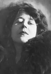 Photographie.Visage de femme aux cheveux bruns, la tête inclinée vers l'arrière. Regard calme, pensif et séduisant