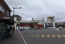 Passerelle en construction au-dessus d'une route et de quais de bus.