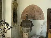 Ancien bénitier et tympan du XIIe&nbsp;siècle qui montre le Christ bénissant entouré de saint Benoît et de sainte Scholastique dans la chapelle Saint-André.