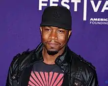 portrait, casquette noire marquée «&nbsp;LA », moustache, barbiche, blouson de cuir