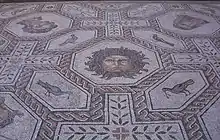 Masque de Méduse cerné de serpents dans un octaèdre entouré de mosaïques d'oiseaux.