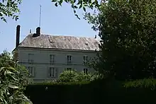 vue de l'ancien moulin avec une haie au premier plan