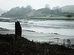 La rivière passe au milieu de larges vasières.