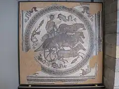 Mosaïque romaine du dieu Neptune debout dans un quadrige de quatre chevaux.