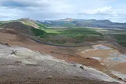 Vue en direction du nord depuis le sommet de la Námafjall avec Hverarönd au premier plan à droite, la route 1 au second plan, la Hlíðardalur au troisième plan et le Krafla à l'horizon.