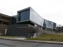 Bâtiment moderne en courbes et verrières, devant un bâtiment au style plus classique.