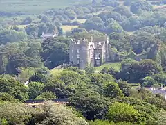 Photo prise de loin d'un grand bâtiment à moitié en ruines au milieu des arbres