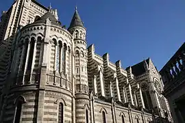  Photographie d'une église, en contreplongée, appareillage de schiste et tuffeau alterné.