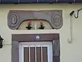 Ornement et niche de porte d'une maison à Schopp à Danne-et-Quatre-Vents, Lorraine.