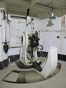 Un des mortiers de 75&nbsp;mm, tirant des obus de 5 à 7&nbsp;kg ; derrière la culasse, une gaine menant à un toboggan permet l'évacuation des douilles jusqu'au dernier étage en bas du bloc.