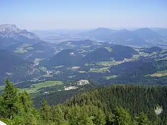 Panorama vers le nord, depuis la route qui mène au Nid d’aigle. Salzbourg est à peine visible au fond. Berchtesgaden se trouve juste sur la gauche en dehors du cadre. Le Kempinski Hotel&nbsp;(de) est au centre, au pied de la montagne.