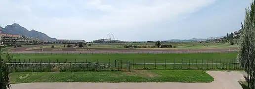 Vue du golf-hippodrome depuis le château Borély du parc Borély voisin, sur fond de mer Méditerranée, massif de Marseilleveyre, îles du Frioul, et château d'If.