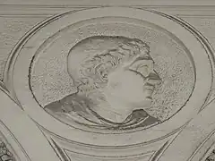 Bas-relief, la tête d'un homme de profil.