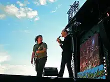 Photographie d'Alan Stivell sur la grande scène du festival de Bobital accompagnant le guitariste Pat O'May