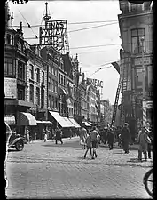 Entrée de la rue en 1934. On aperçoit l'enseigne du Cinéac et une publicité pour les cigarettes Kyriazi Freres&nbsp;(en). Photo de Paul Guermonprez.