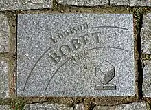 Photographie d'un pavé gris gravé.