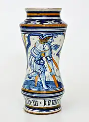 Albarello de pharmacie décoré d'un motif « feuille froissée », sur le devant la figure d'un homme avec des béquilles, Pesaro, fin XVe&nbsp;siècle.