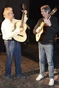 Pierre perret accorde sa guitare avec son guitariste Joël Roulleau