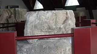 Photographie en couleurs d'un assemblage de blocs sculptés représentant un personnage.