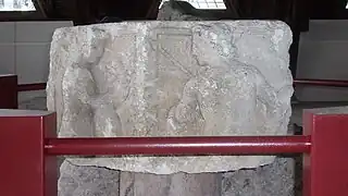 Photographie en couleurs d'un assemblage de blocs sculptés représentant un personnage.