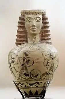 Aryballe en forme de protomé féminin avec combat de hoplites et chasse au lièvre, h. 7,2&nbsp;cm. Protocorinthien récent, vers 650-630, Paris, musée du Louvre.