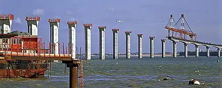 Construction du pont. La poutre de lancement de manipulation des voussoirs mesurait 285&nbsp;m de long. Elle fut démontée sur l'île à la fin des travaux.