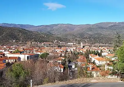 Vue vers le centre-ville, depuis le chemin de la Rouffaque. Le centre-ville est situé sur une terrasse de la Têt qui se trouve à environ 20 mètres au-dessus de l'altitude du cours actuel de la rivière. L'église (avec sa tour proéminente) est située au sud de la rivière ; l'hôpital (le grand bâtiment blanc à l'arrière de la ville) est situé au nord de la rivière,,.
