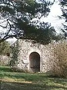 Vue du pignon d'une chapelle percé d'une porte romane.