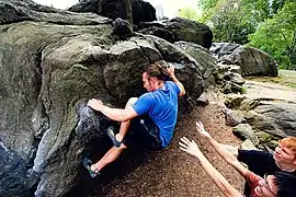 Un homme qui grimpe un rocher.