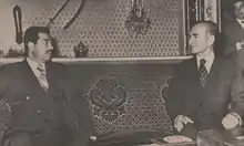 Deux hommes en costume en discussion.