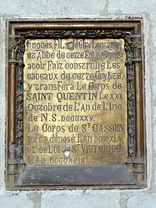 Plaque de bronze gravée et incrustée dans un mur en pierre