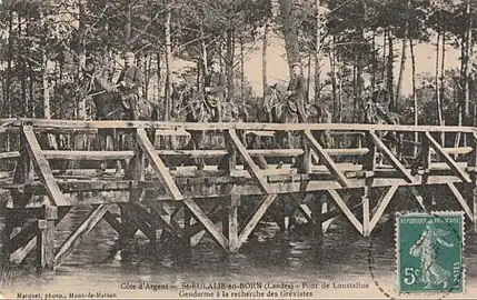 Grève des résiniers (1906-1907), gendarmes à cheval traversant le courant de Sainte-Eulalie par le pont de l'Oustaline à la recherche de grévistes.