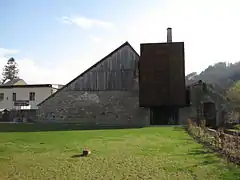 Photographie en couleurs d'un bâtiment entouré de pelouse.