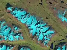 Vue aérienne du Sarektjåhkkå, de jour, la neige descend presque jusqu'à la vallée.