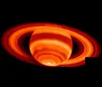 Image en nuances rouges de SAturne et de ses anneaux, le pôle sud est le point le plus clair de l'image.