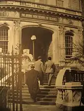 Photo ancienne sépia de la volée d'escaliers et de la grille d'entrée en façade d'une école du Bronx.