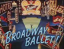 Décor de Times Square illuminé. Au centre, dans les feux des projecteurs, un homme est debout les bras écartés. En majuscules et en grosses lettres bleues, le texte Broadway Ballet.