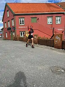 Traileur devant une maison rouge.