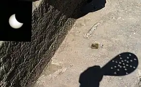 Utilisation de l'effet sténopé pour observer sans danger une éclipse à travers les trous d'une passoire.