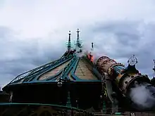 Tube cuivré entouré de fumée reposant sur un structure conique.