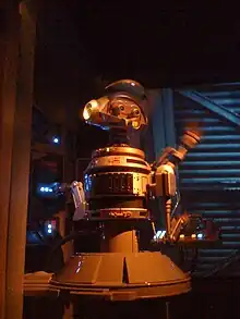 Robot gris et bleu devant un écran.