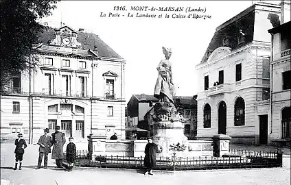 Photo ancienne de la place, ornée de la statue La Landaise avec le bâtiment de la Poste (à gauche) et de la Caisse d'Epargne (à droite).