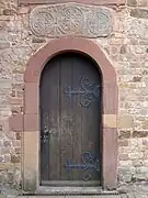 Porte latérale avec linteau roman.