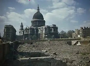 Vers la fin de la Seconde Guerre mondiale, vue de la cathédrale et, au premier plan, la jouxtant, un des secteurs de Londres qui ont été totalement détruits pendant le conflit (et dont la plupart des décombres ont vite été évacués). On constate que le monument semble avoir échappé de peu au même sort, ou du moins à des dommages bien plus importants que ceux qu'il a subi.