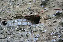 Photographie en couleurs d'un mur percé pour y faire passer une canalisation.
