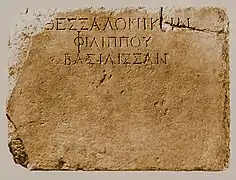 Inscription : ΘΕΣΣΑΛΟΝΙΚΗΝ ΦΙΛΙΠΠΟΥ ΒΑΣΙΛΙΣΣΑΝ «&nbsp;à la reine Thessalonique, fille de Philippe&nbsp;», qui a donné son nom à la ville. Provient d'un piédestal du -IIe siècle, avec des statues de la famille de Philippe II.