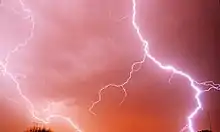 Photo d'éclairs zébrant un ciel rougeoyant