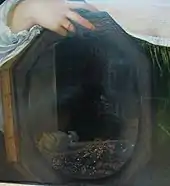 Peinture représentant, dans le reflet d'un miroir, un table couverte de pièces et autres richesses.