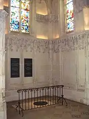 Photo couleur représentant une chapelle au sol de laquelle se trouve une pierre tombale.