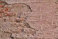 Exemple de protection de briques foraines incuites par un enduit sur lequel a été réalisé un travail de briquetage (faux joints).